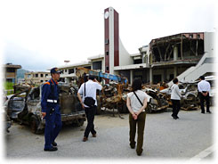 津波で大破した車や建物を視察する参加者